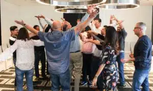Image of a happy group of people celebrating with arms in the air